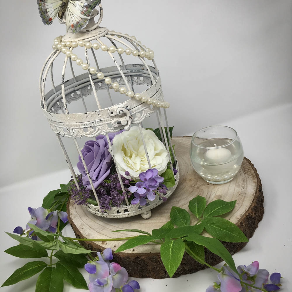 Lilac birdcage centrepiece on rustic wood